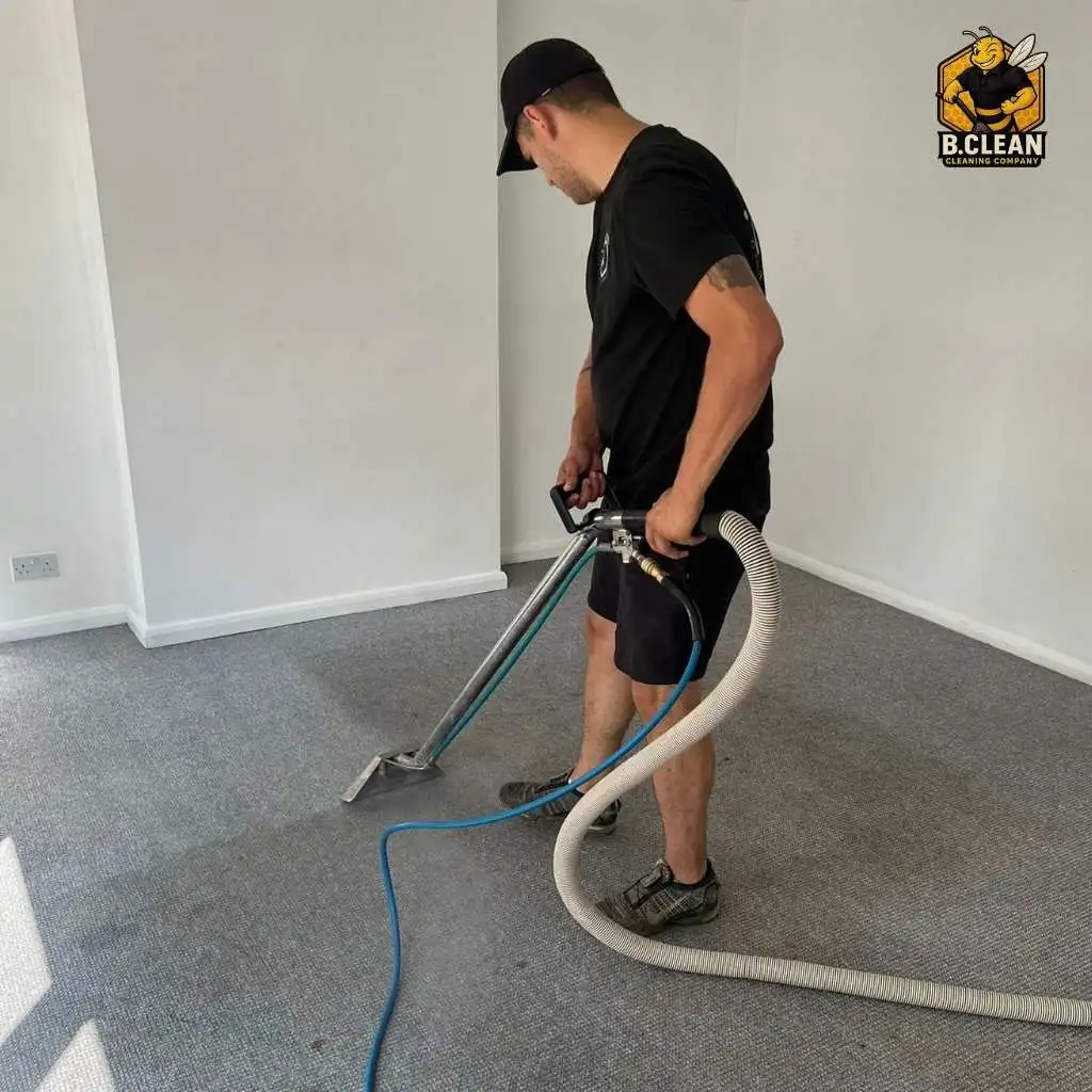 Brennan Budden from Channel 5 Filthy House SOS using a carpet cleaning machine in an empty room with light grey walls and grey carpet. Highlighting effectiveness of carpet cleaning in Kent by B Clean Cleaning.