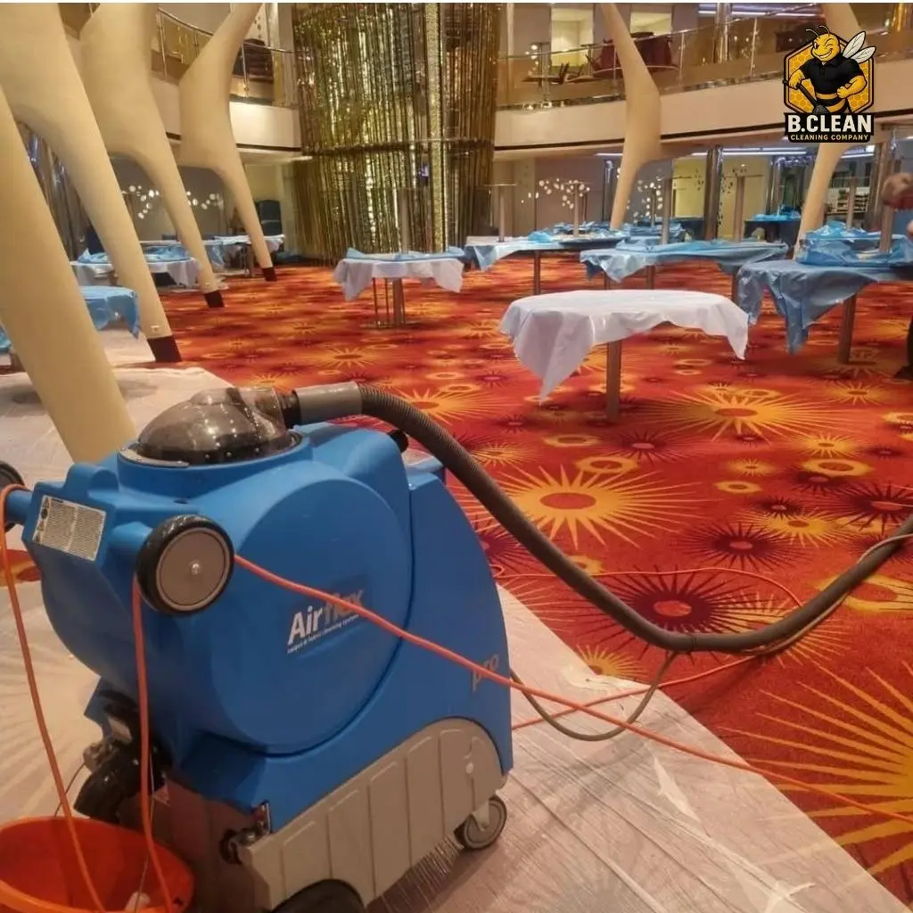 Channel 5s Brennan Budden of Filthy House SOS with carpet cleaning machine cleaning orange commercial carpets around tables with white linen as part of commercial cleaning in Kent by B Clean Cleaning